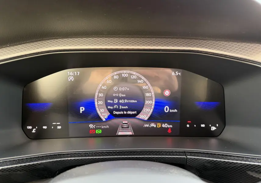 Vue rapprochée du combiné d'instruments digital du Volkswagen T-Cross gris, affichant vitesse et informations de conduite.
