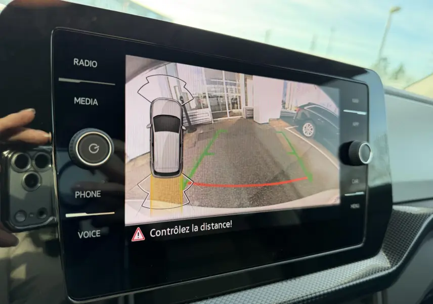 Écran tactile intérieur montrant la caméra de recul avec indications visuelles du Volkswagen T-Cross gris.