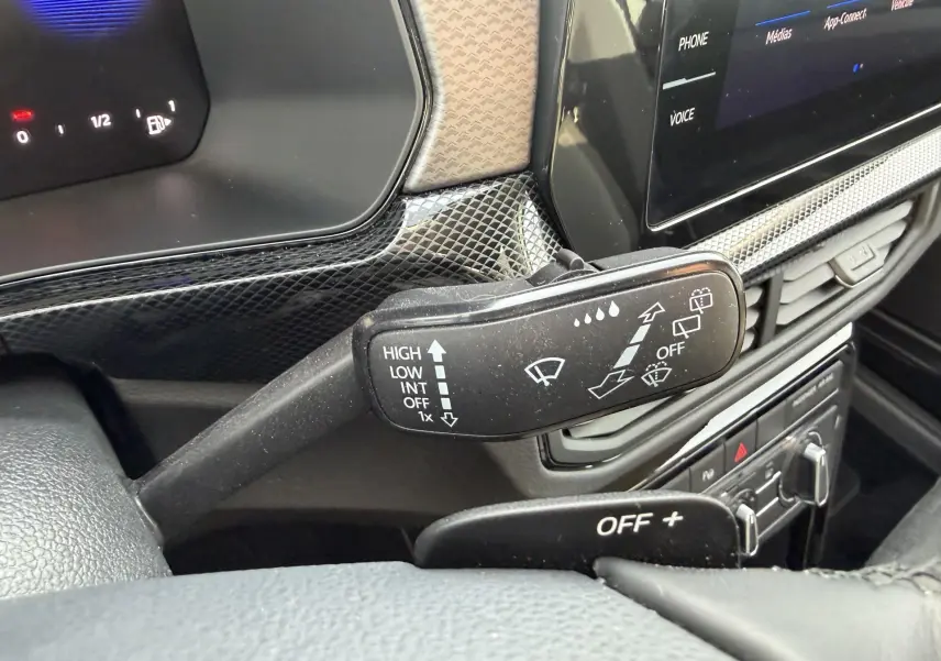 Gros plan sur la commande d’essuie-glace du Volkswagen T-Cross 2025, intérieur noir avec écran tactile visible.