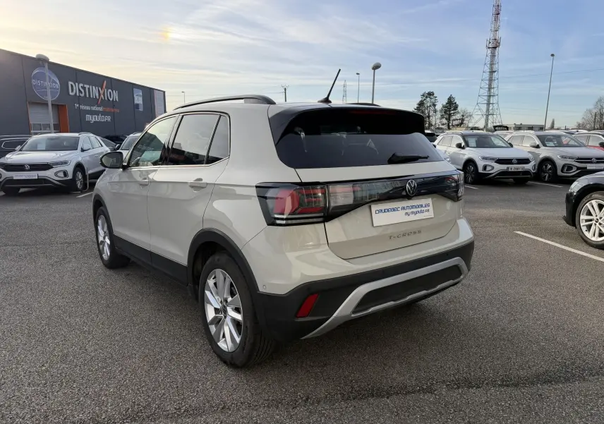 Volkswagen T-Cross gris clair vu en 3/4 arrière droit, avec toit noir et jantes alliage visibles en extérieur.