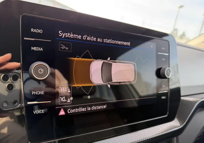 Image montrant l'écran tactile du système d'aide au stationnement du Volkswagen T-Cross gris, vue intérieure du tableau de bord.