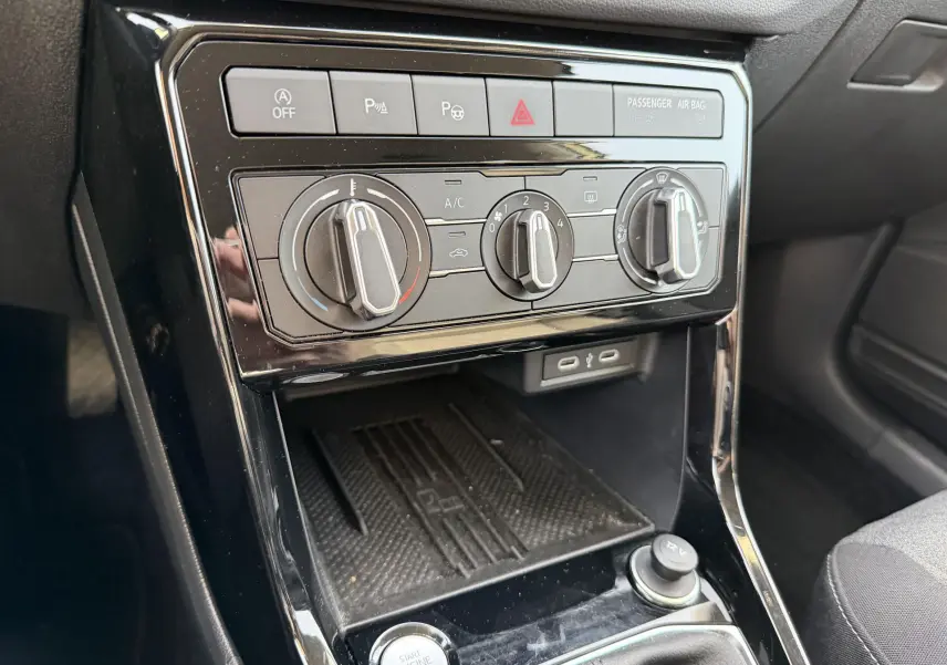 Vue rapprochée de la console centrale du Volkswagen T-Cross 2025, avec commandes de climatisation manuelle et bouton start/stop.