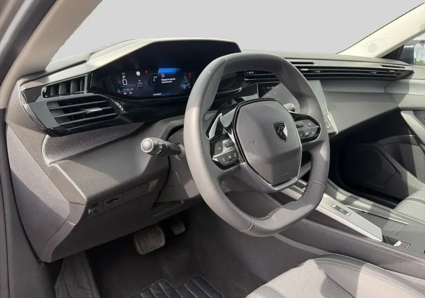 Intérieur de la Peugeot 308 2025, vue côté conducteur sur le volant multifonction et tableau de bord numérique.