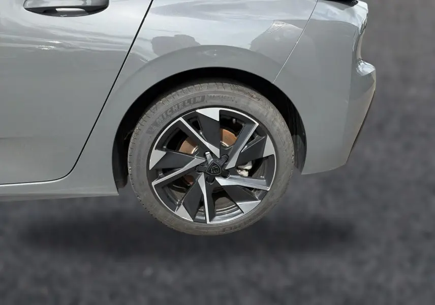 Gros plan sur la roue arrière droite d'une Peugeot 308 gris selenium avec jante alu au design moderne.