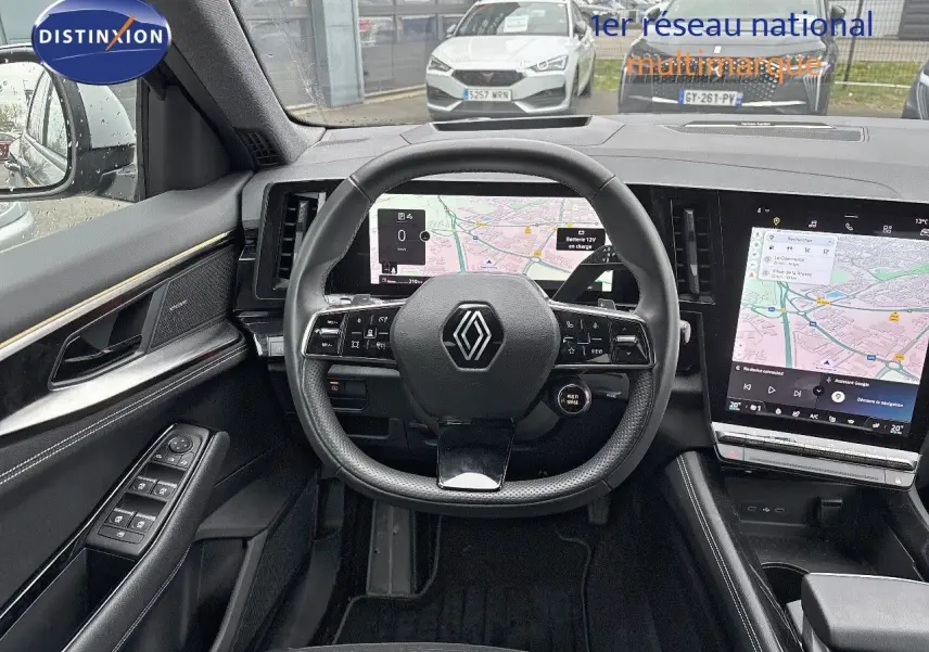 Vue intérieure centrée sur le volant et les écrans numériques du tableau de bord du Renault Austral noir étoile métal 2023.