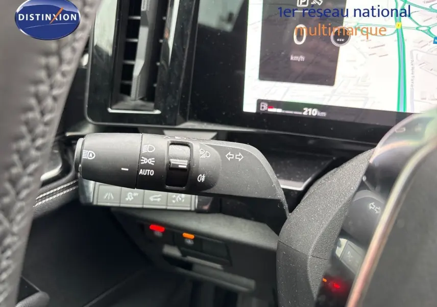 Gros plan sur la commande des feux et clignotants à gauche du volant dans le tableau de bord du Renault Austral noir étoile métal 2023.