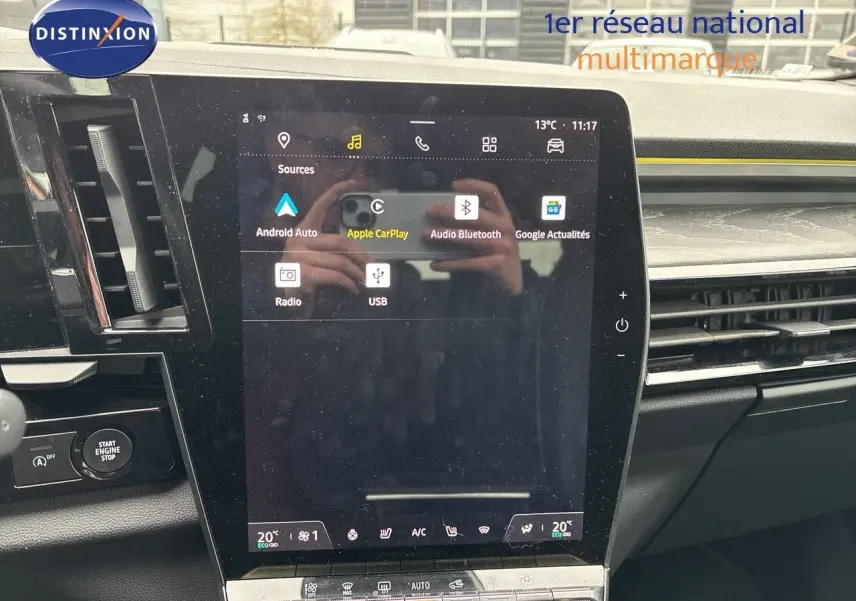 Écran tactile central affichant les options multimédia d'un Renault Austral noir, avec tableau de bord et commandes visibles.