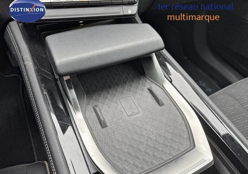 Détail de la console centrale noire avec accoudoir et surface de recharge sans fil du Renault Austral 2023.