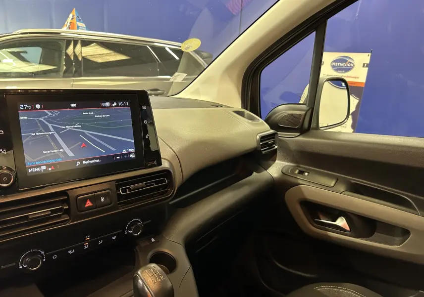 Vue intérieure côté passager du Peugeot Rifter gris sable 2019 avec écran GPS et boîte manuelle visible.