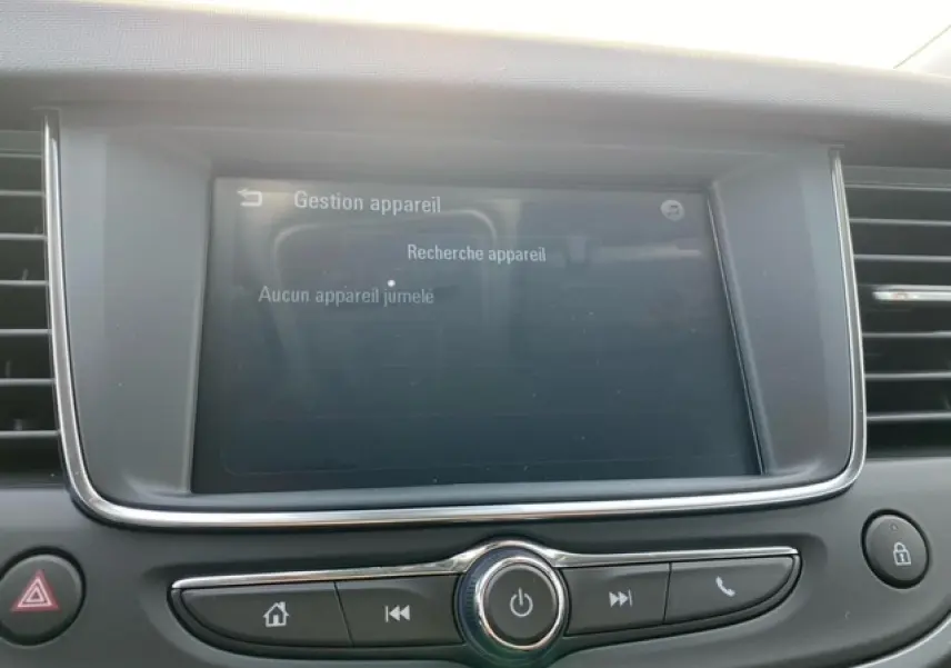 Écran tactile multimédia allumé au centre du tableau de bord de l'Opel Crossland noir métal, vue intérieure frontale.