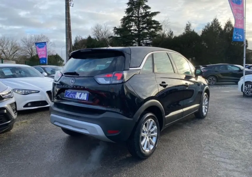 Vue 3/4 arrière droite d'un Opel Crossland noir métal 2022 avec feux arrière halogène et jantes alliage.
