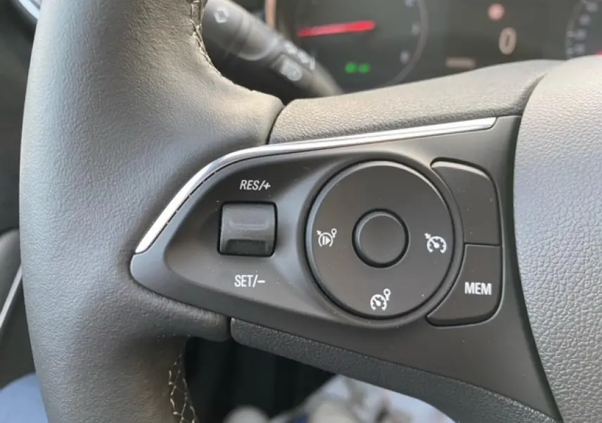 Gros plan sur les commandes de régulateur de vitesse au volant cuir noir de l'Opel Crossland 2022 finition X Elégance