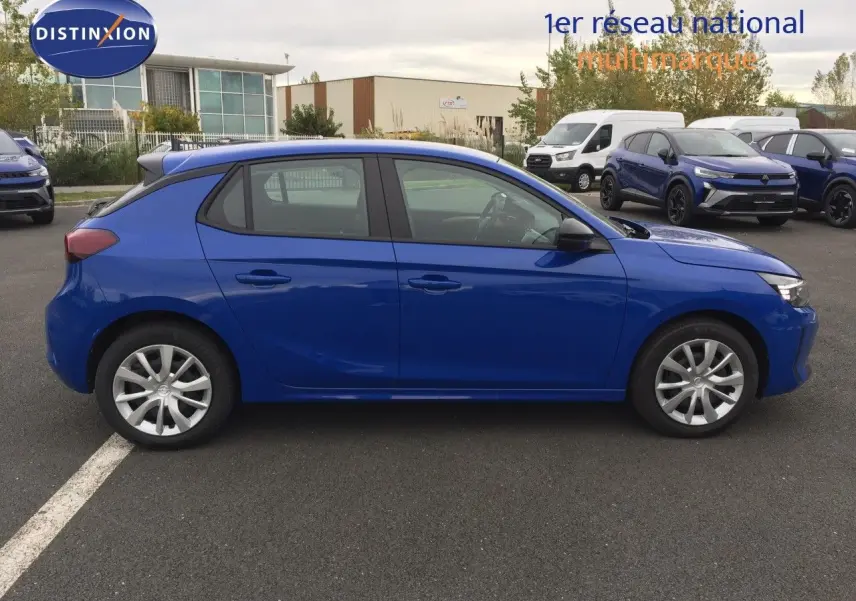 Profil côté gauche d'une Opel Corsa 2025 bleu voltaik metal garée sur un parking, avec jantes argentées et vitres teintées.