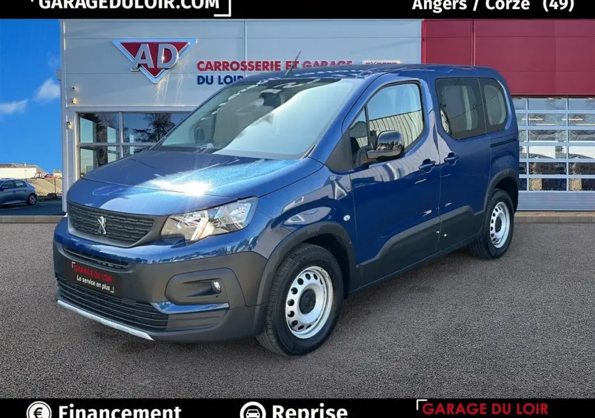 Vue 3/4 avant droite d'un Peugeot Rifter bleu avec jantes tôles et porte latérale coulissante visible.