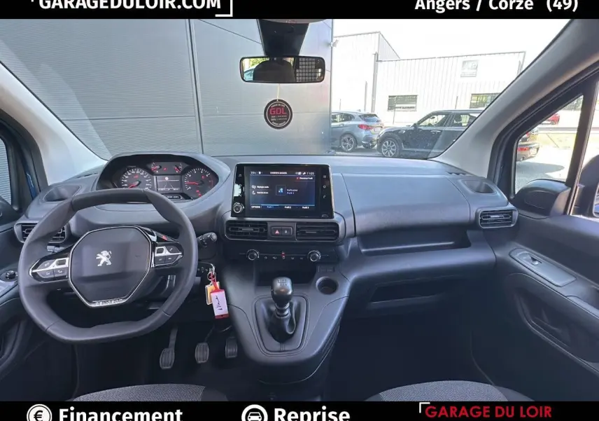 Intérieur Peugeot Rifter 2024 vu de face, tableau de bord noir avec écran tactile central et volant multifonction.