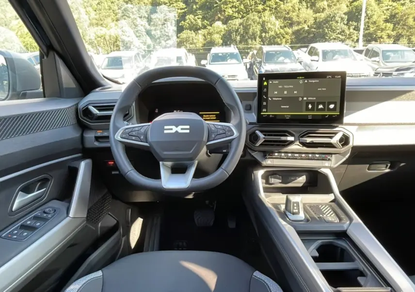 Intérieur du DACIA Bigster 2025 vu de face, volant cuir et écran tactile 10 pouces au tableau de bord.
