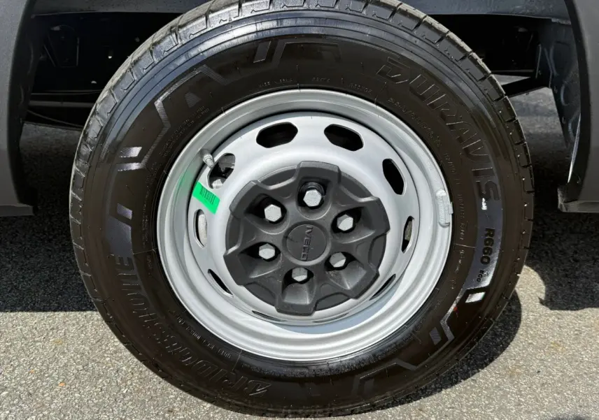 Gros plan sur la roue avant droite du fourgon Iveco Daily blanc, mettant en valeur la jante acier et le pneu Bridgestone.