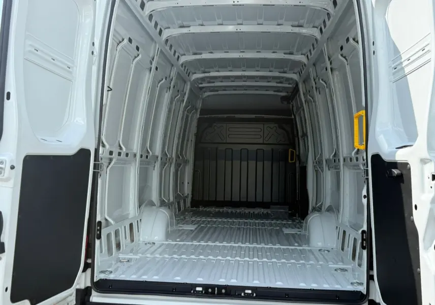 Vue intérieure arrière du fourgon blanc Iveco Daily 35S18 2026, montrant l'espace de chargement vide et les portes ouvertes.