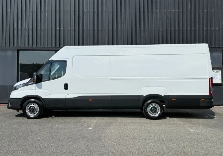 Fourgon Iveco Daily blanc vu de profil côté gauche, avec bas de caisse noir et jantes acier simples.