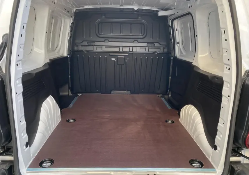 Vue intérieure arrière du Peugeot Partner Fourgon blanc, montrant la zone de chargement avec plancher en bois et anneaux d’arrimage.