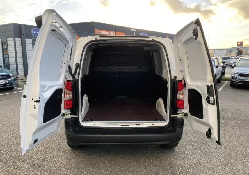 Vue arrière du Peugeot Partner Fourgon blanc 2025 avec portes arrière ouvertes montrant l'espace de chargement vide.