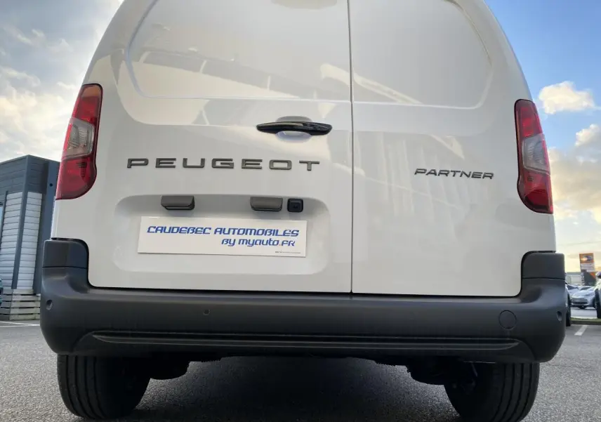 Vue arrière du Peugeot Partner Fourgon blanc, mettant en valeur les portes battantes et le pare-chocs noir.
