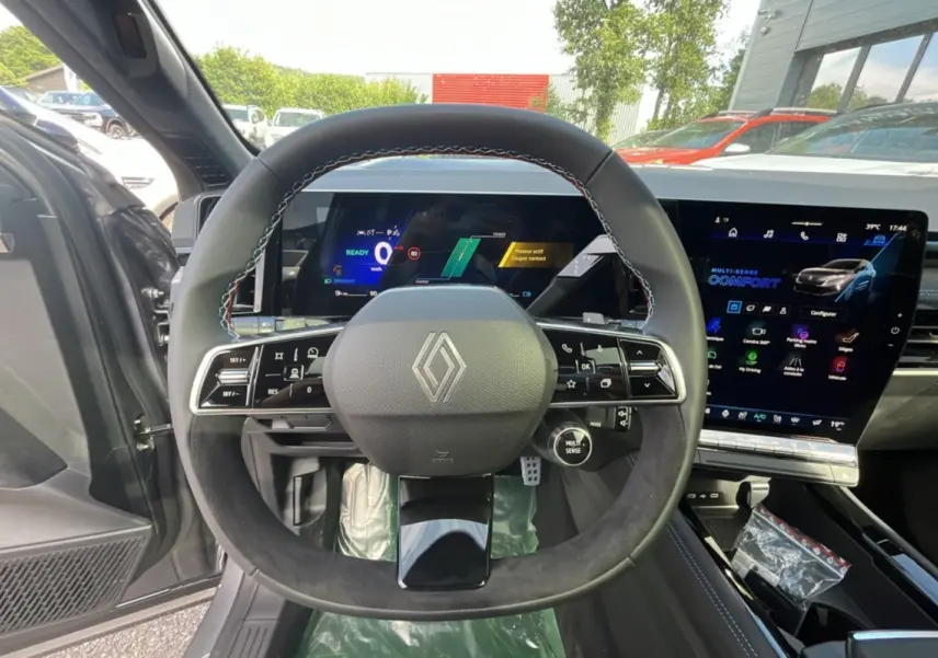 Vue intérieure centrée sur le volant cuir multifonctions du Renault Austral 200 Esprit Alpine, avec écran tactile et tableau de bord numérique.
