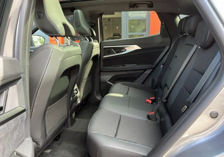Vue intérieure arrière droite du Renault Austral 200 Esprit Alpine, montrant les sièges semi-alcantara noirs et les finitions modernes.