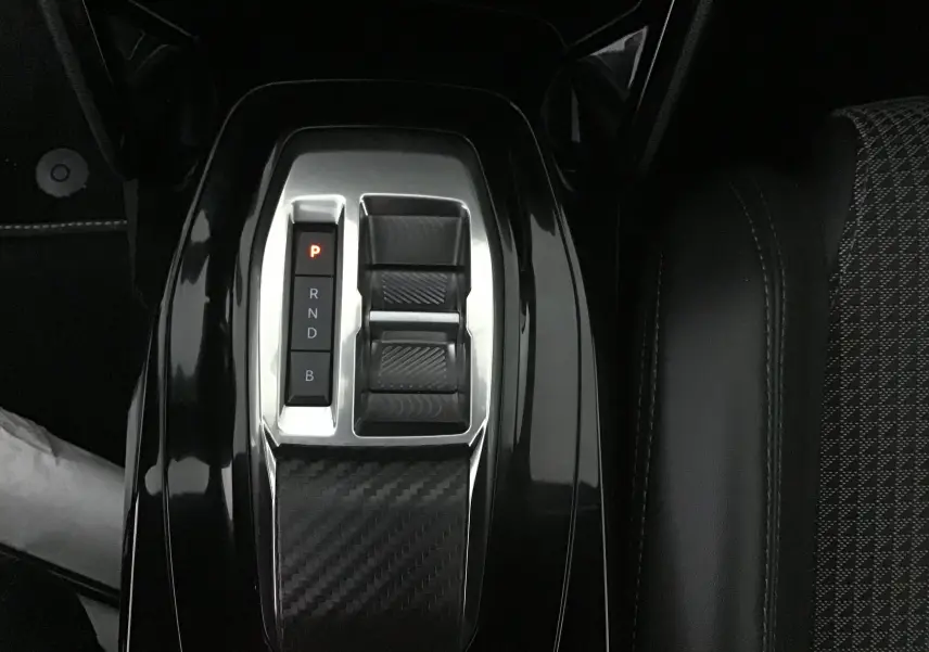 Gros plan sur la console centrale noire brillante avec sélecteur de boîte automatique du Peugeot 2008 électrique 2022.