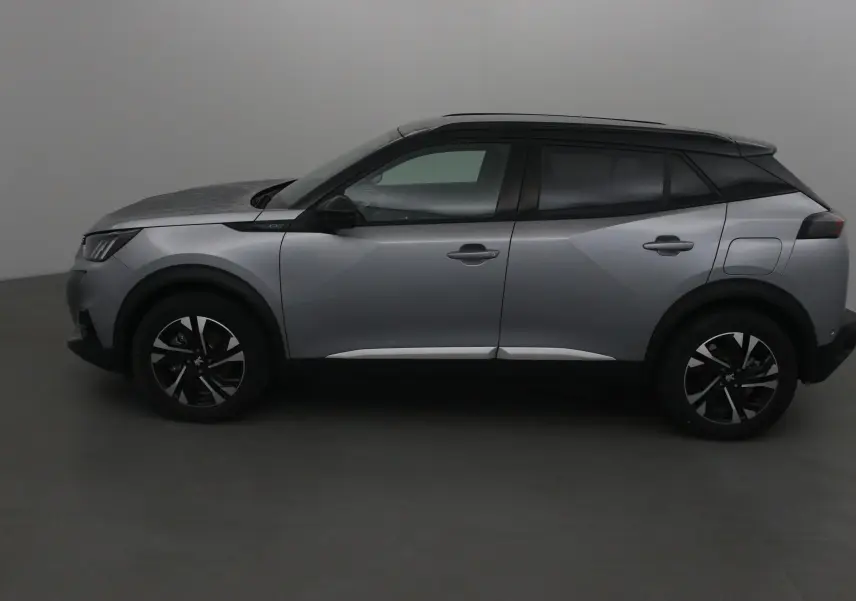 Profil côté gauche du Peugeot 2008 électrique 2022 en gris Artense avec toit noir et jantes noires distinctives.