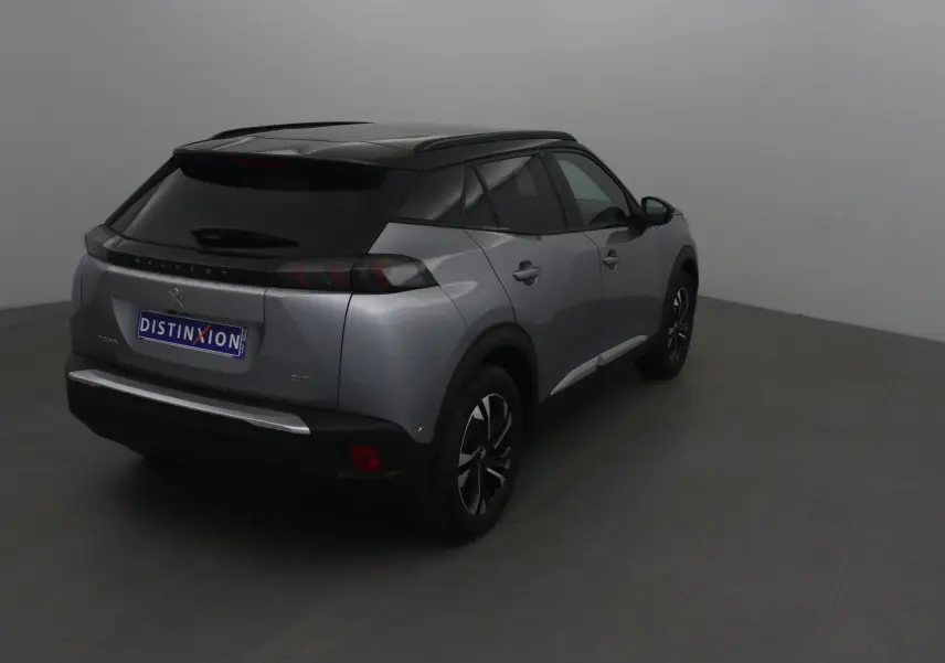 Peugeot 2008 électrique gris Artense avec toit noir, vue 3/4 arrière droit dans un studio neutre.