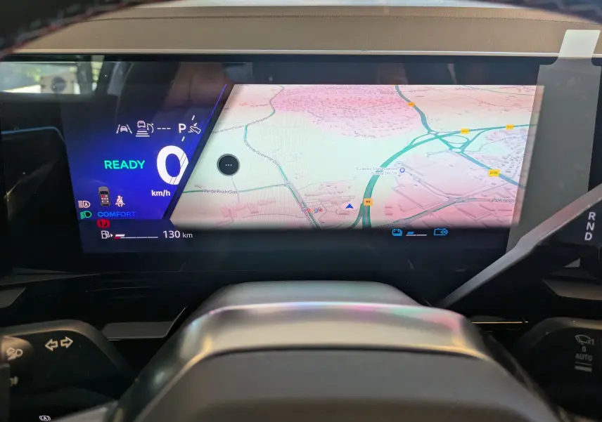 Vue intérieure du tableau de bord numérique du Renault Espace VI hybride, affichant la navigation et les indicateurs de conduite.