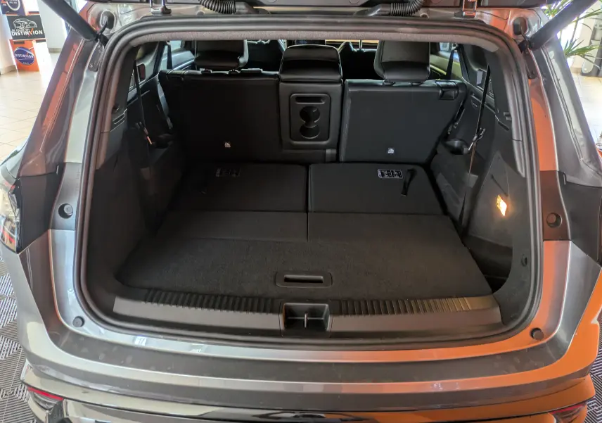 Coffre ouvert vu de l'arrière d'un Renault Espace VI gris schiste avec banquette arrière partiellement rabattue.