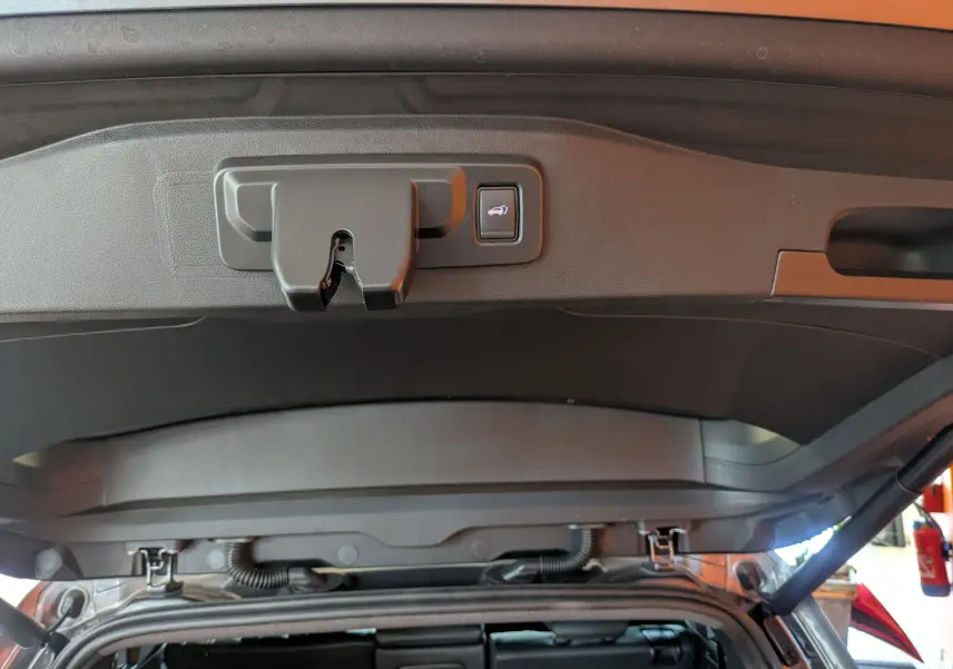 Détail du mécanisme d'ouverture du hayon arrière du Renault Espace VI gris schiste, vue intérieure du coffre ouvert.