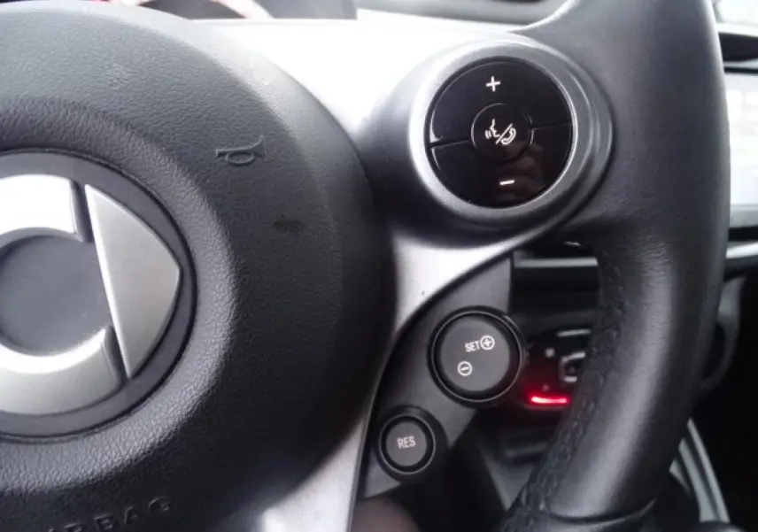 Gros plan sur le volant cuir multifonctions noir de la Smart Forfour Electric Drive Prime 2018 avec commandes au volant.