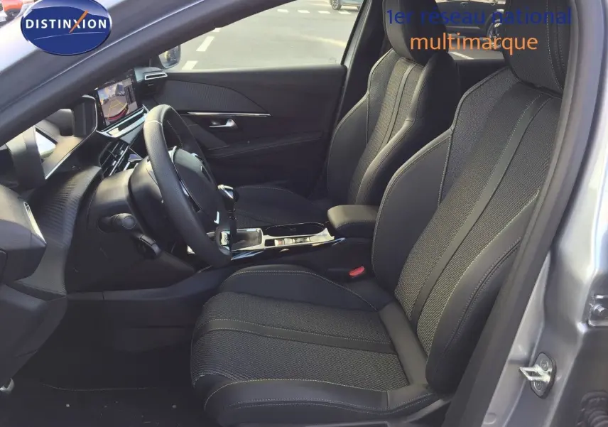 Vue intérieure côté conducteur d'une Peugeot 208 2025 gris Artense, sièges en cuir noir et tableau de bord moderne.