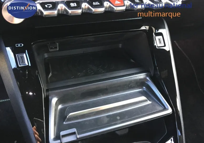 Détail de la console centrale noire brillante avec compartiment ouvert et rangée de boutons sur une Peugeot 208 Gris Artense 2025