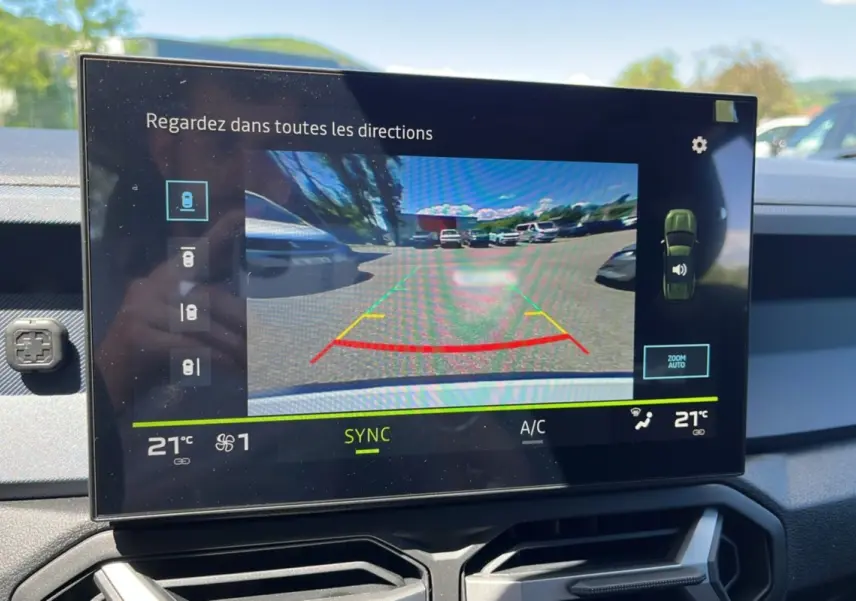 Écran tactile intérieur du Dacia Bigster montrant la caméra multiview en marche avec vue arrière en plein jour.