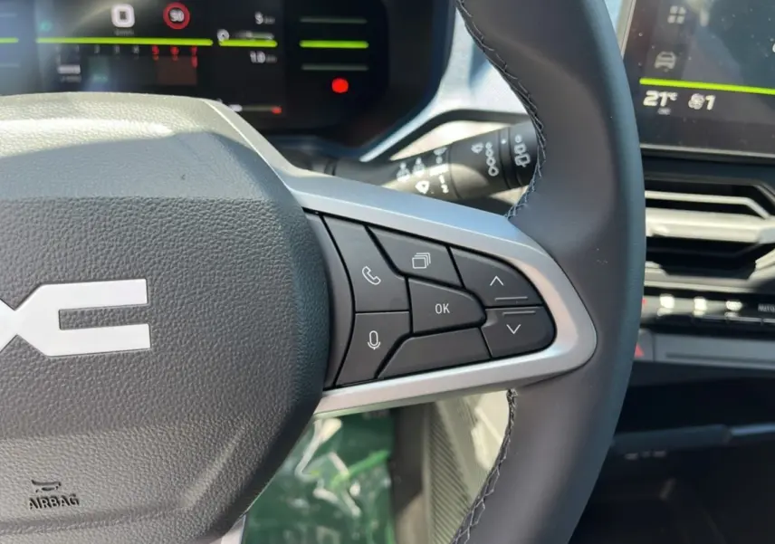 Gros plan sur le volant cuir du Dacia Bigster 2025 avec commandes multifonctions et tableau de bord numérique.