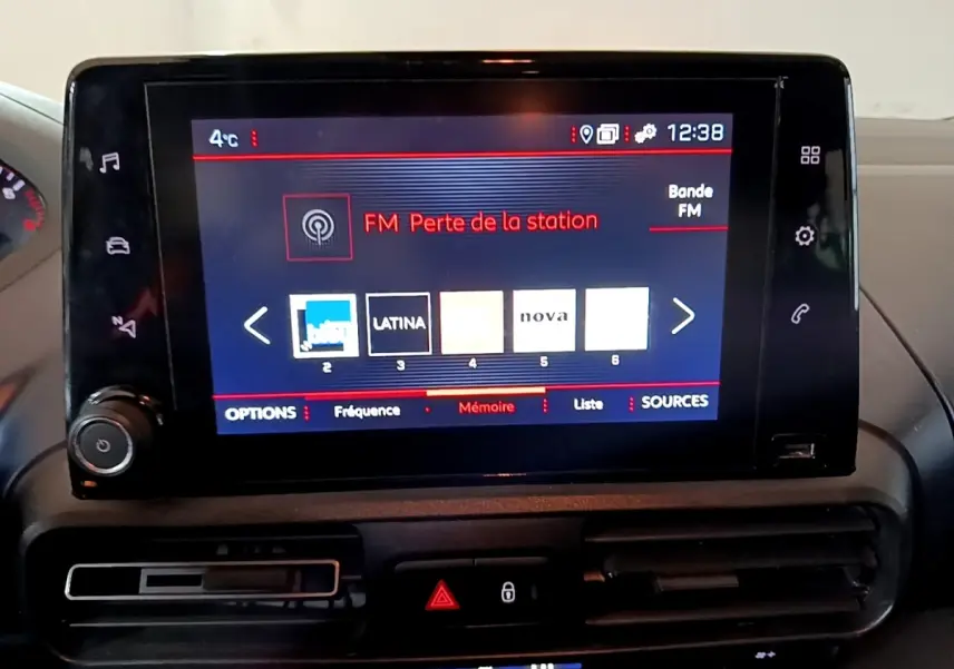 Écran tactile central du tableau de bord du Peugeot Rifter marron, affichant les stations radio FM.