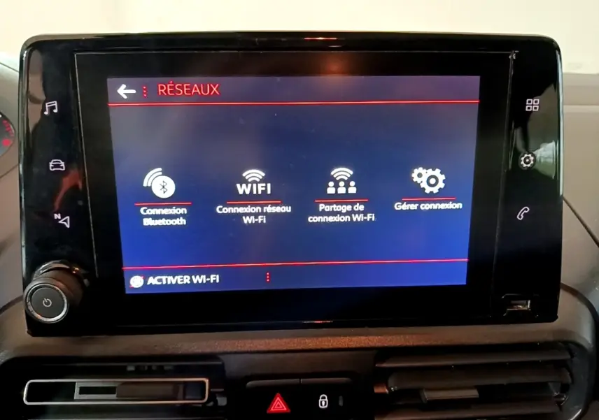 Écran tactile central du tableau de bord du Peugeot Rifter marron 2019 affichant les options de connexion Wi-Fi et Bluetooth.