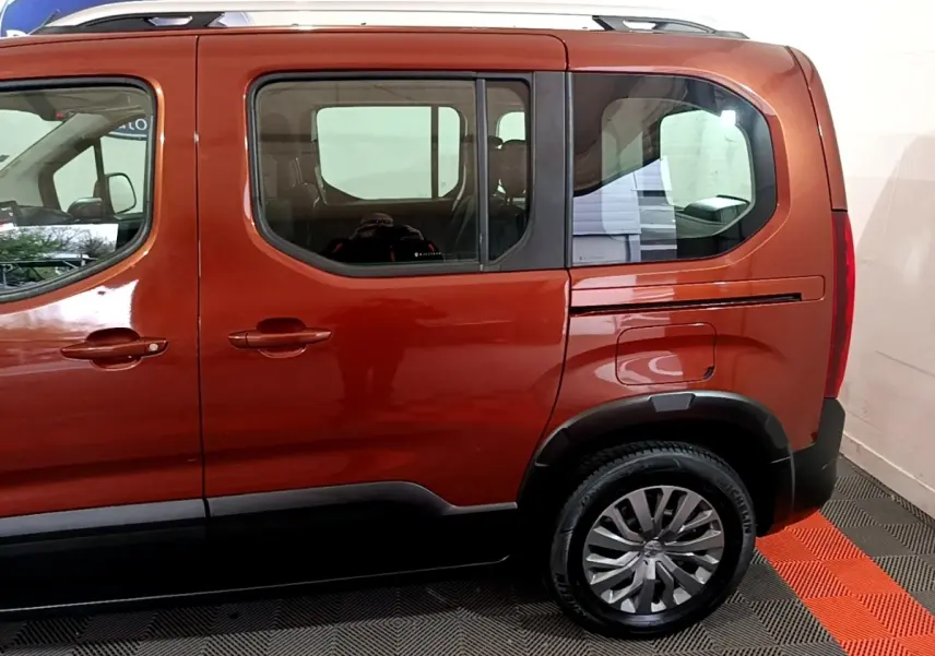 Vue latérale côté droit du Peugeot Rifter marron 2019 avec jantes alliage et rails de toit chromés visibles.