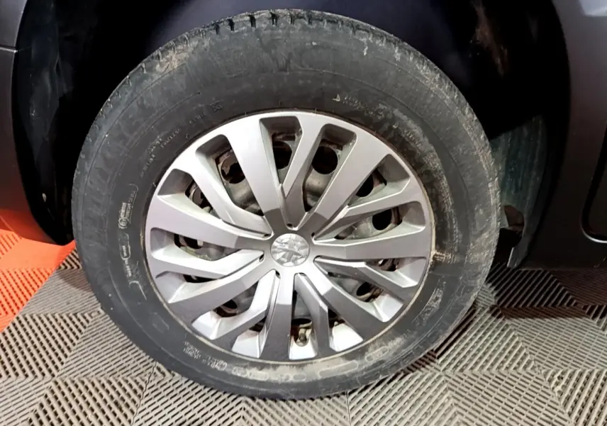 Gros plan sur la roue avant gauche du Peugeot Rifter marron 2019 avec jante alliage au design moderne.