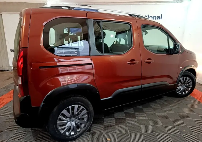 Vue latérale droite d'un Peugeot Rifter BlueHDi 100 Allure marron avec barres de toit chromées et jantes alliage.