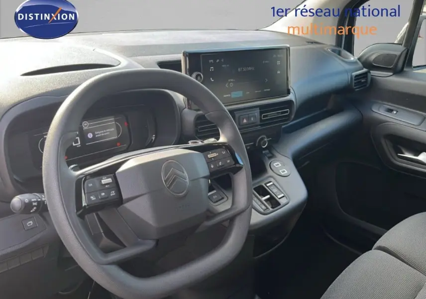 Vue intérieure côté conducteur du Citroën Berlingo 2025, tableau de bord noir avec écran tactile et volant multifonction.