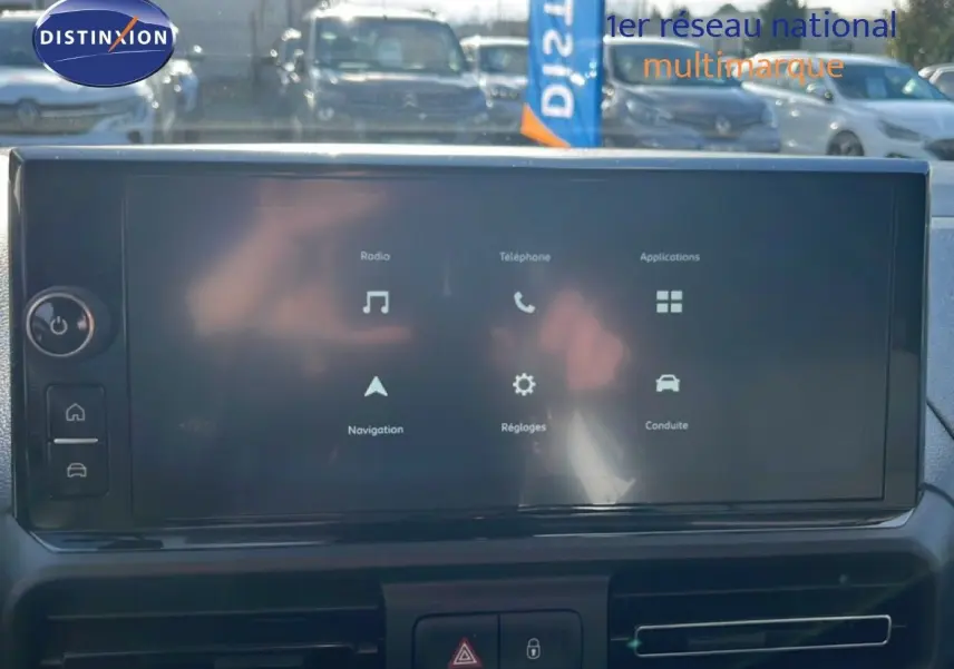 Écran tactile central du tableau de bord du Citroën Berlingo blanc, affichant les menus radio, téléphone et navigation.