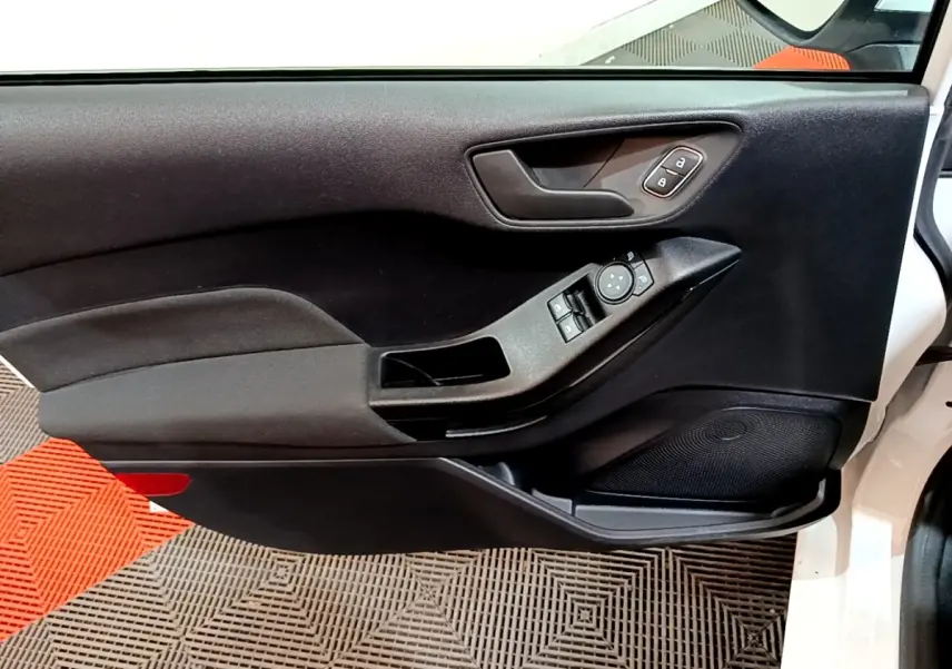 Vue intérieure côté gauche de la porte avant blanche de la Ford Fiesta 2022 avec commandes électriques et poignée noire.