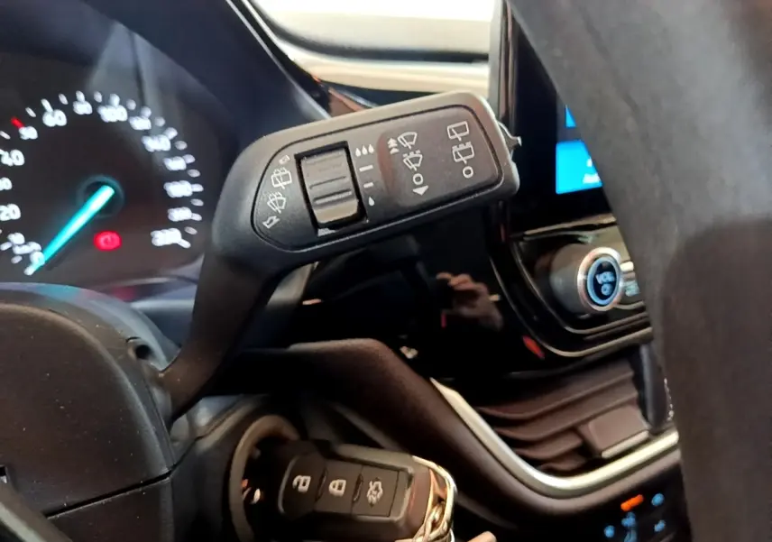 Gros plan intérieur sur la commande d’essuie-glace et le tableau de bord numérique d’une Ford Fiesta 2022 blanche.