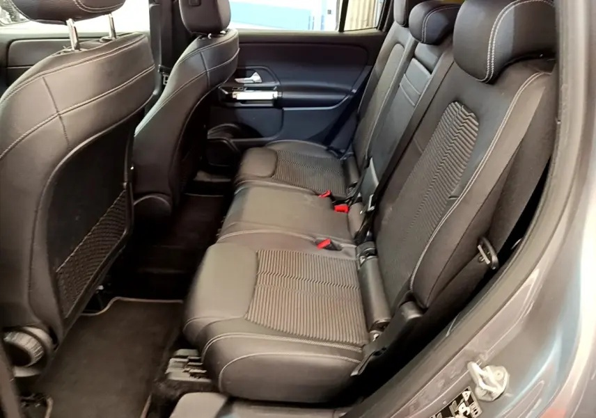 Vue côté gauche de la banquette arrière en tissu noir du Mercedes GLB 200 d Business Line gris foncé, avec appuie-têtes visibles.