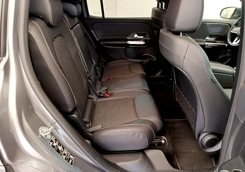 Vue intérieure côté gauche sur la banquette arrière en tissu noir du Mercedes GLB 200 d Business Line gris foncé.